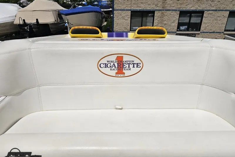 Slide: The Image of 2002 Cigarette 42' Tiger boat interior with logo, featuring white seating and yellow accents. - 90