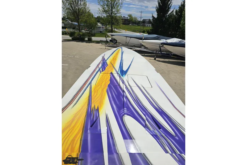 Slide: The Image of 2002 Cigarette 42' Tiger boat with vibrant purple and yellow graphics on deck. - 71