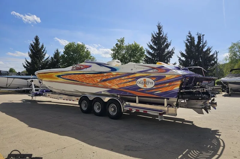 Slide: The Image of 2002 Cigarette 42' Tiger speedboat with vibrant custom paint on a trailer. - 32