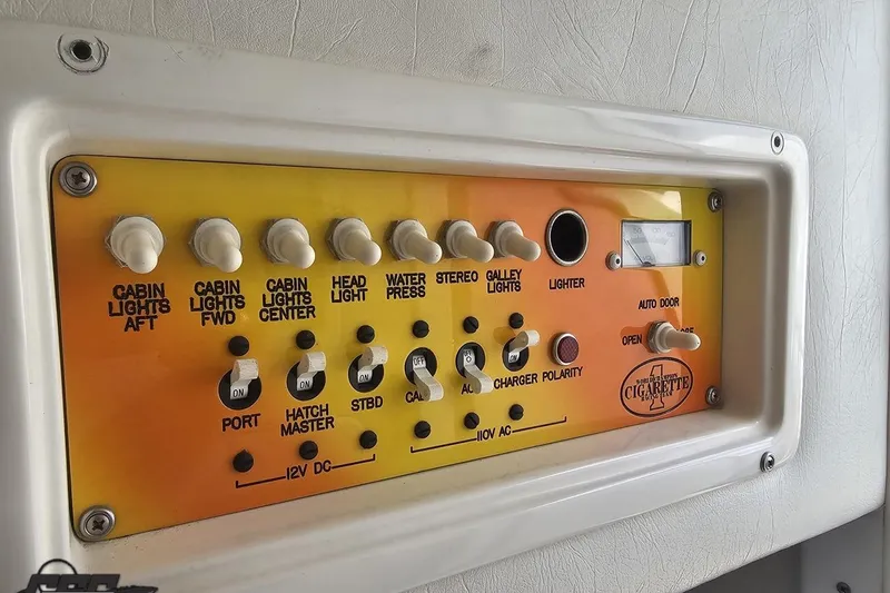 Slide: The Image of Control panel of a 2002 Cigarette 42' Tiger boat with various switches and indicators. - 81