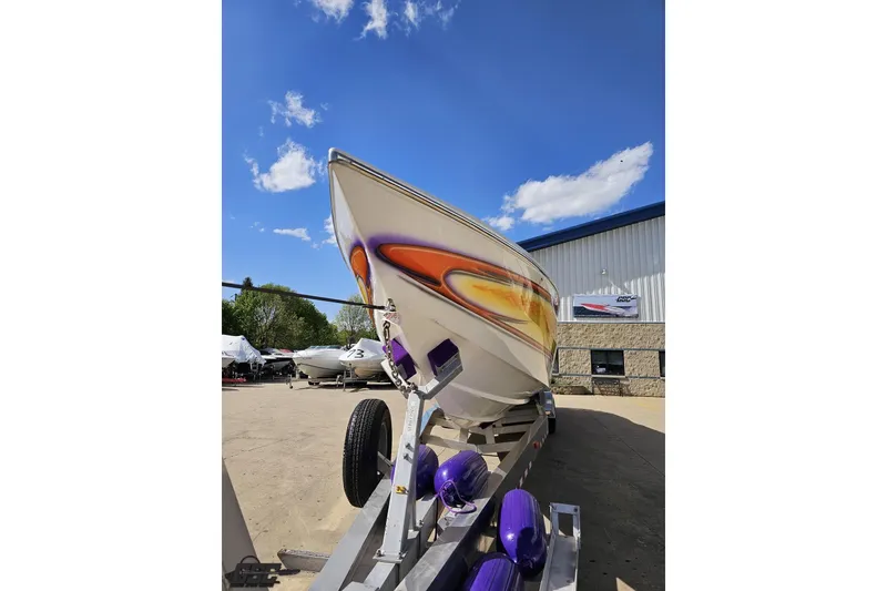 Slide: The Image of 2002 Cigarette 42' Tiger boat on trailer, vibrant design, clear sky background. - 17