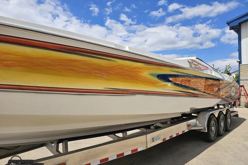 Slide: The Image of 2002 Cigarette 42' Tiger boat with vibrant flame design on trailer. - 21
