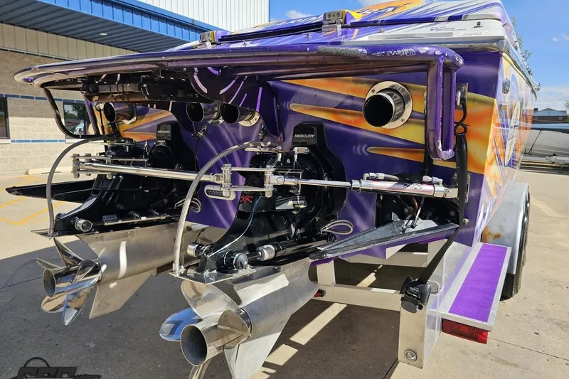 Slide: The Image of Rear view of a 2002 Cigarette 42' Tiger boat with vibrant graphics and dual Mercury engines. - 36
