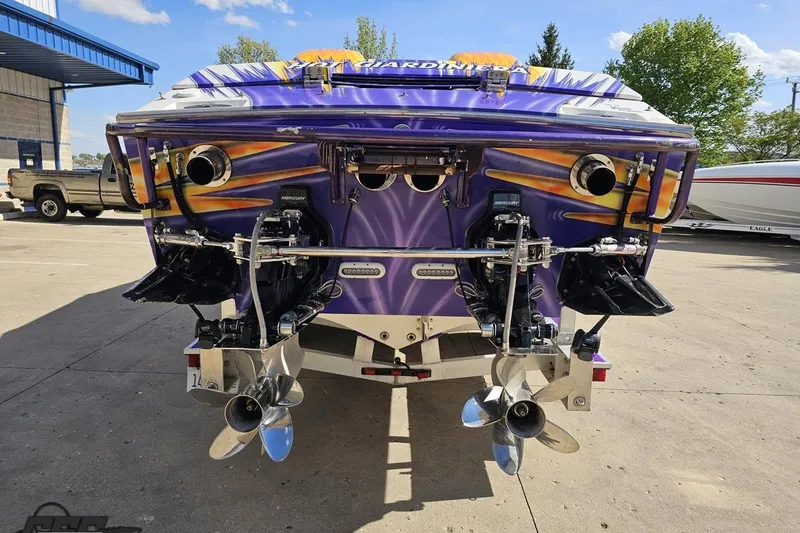 Slide: The Image of 2002 Cigarette 42' Tiger boat with vibrant purple and yellow design, docked outdoors. - 34