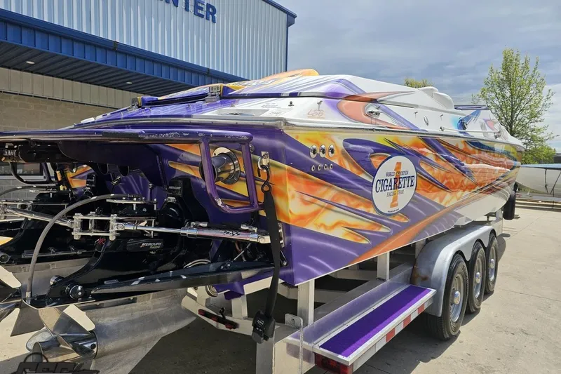 Slide: The Image of 2002 Cigarette 42' Tiger speedboat with vibrant flame graphics on a trailer. - 39