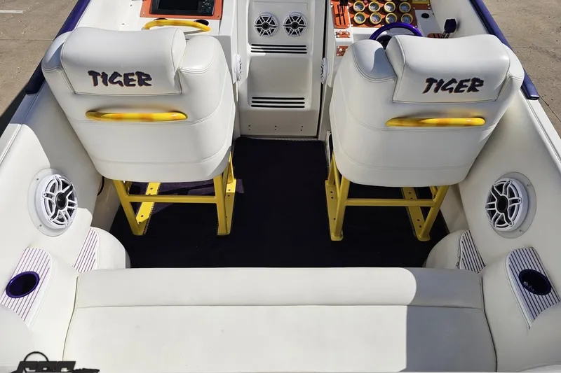 Slide: The Image of Interior of a 2002 Cigarette 42' Tiger boat with white seating and yellow accents. - 52