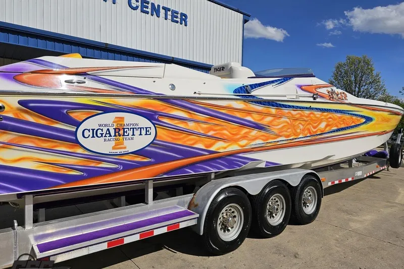 Slide: The Image of 2002 Cigarette 42' Tiger speedboat with vibrant flame graphics on a trailer. - 10
