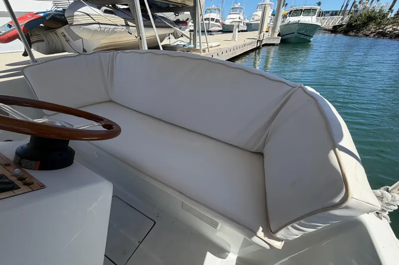 Slide: The Image of Interior of a 1996 Duffy 16 boat with white seating and wooden steering wheel. - 17