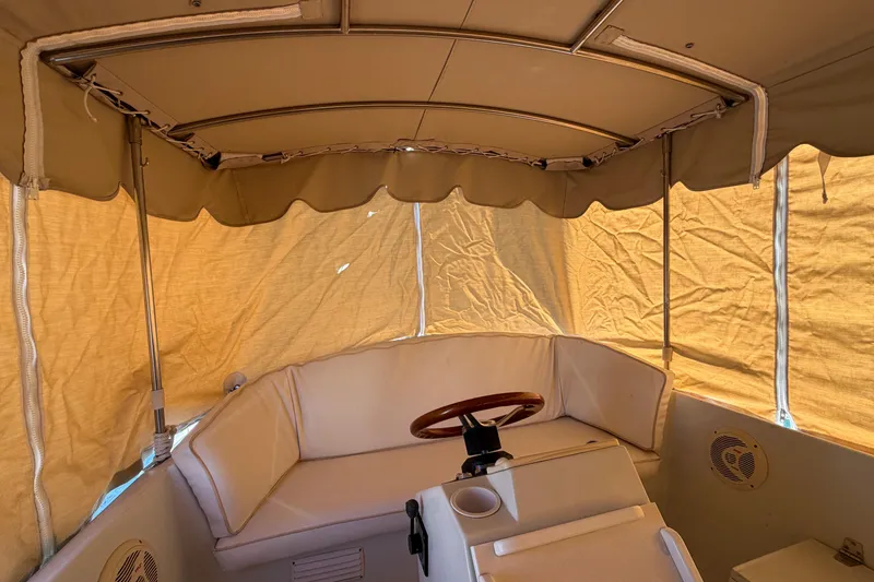 Slide: The Image of Interior of a 1996 Duffy 16 boat with beige canopy and seating. - 22