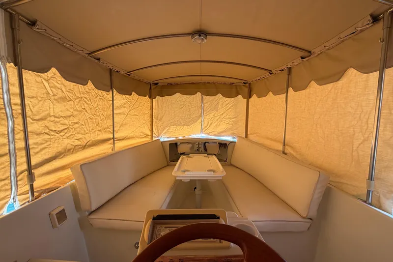 Slide: The Image of Interior of a 1996 Duffy 16 boat with beige canopy and seating. - 21