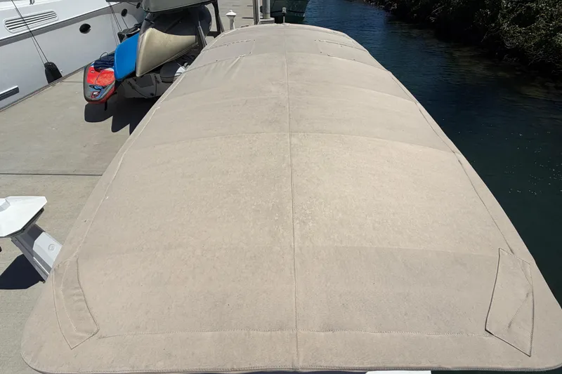 Slide: The Image of Covered 1996 Duffy 16 boat docked beside water, with nearby jet ski. - 19