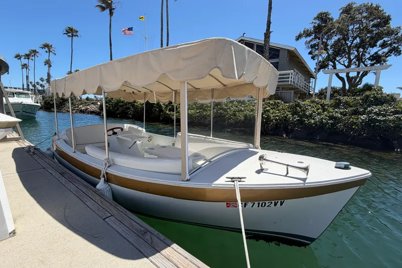 Slide: The Image of 1996 Duffy 16 boat docked by a waterfront house, under a clear blue sky. - 5