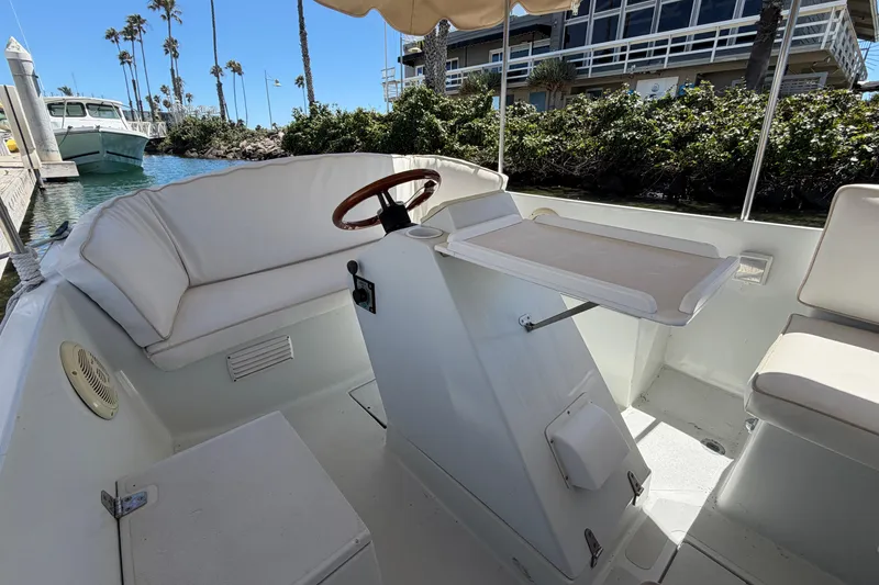 Slide: The Image of Interior of a 1996 Duffy 16 boat with white seating and steering wheel. - 15