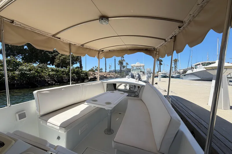 Slide: The Image of 1996 Duffy 16 boat interior with canopy, docked at marina under clear blue sky. - 9