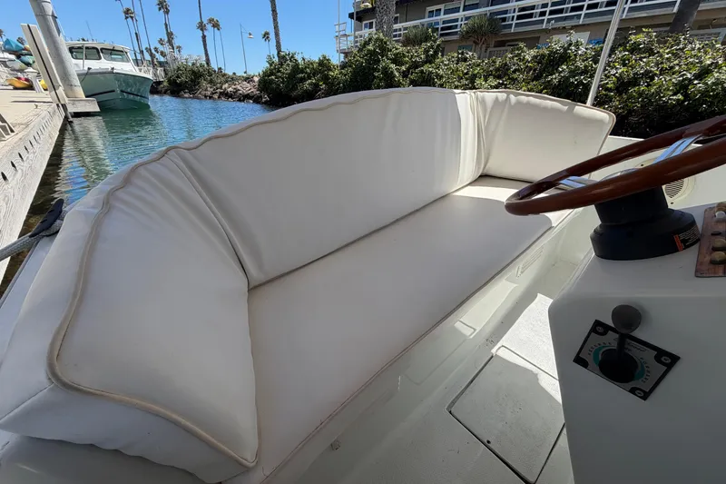 Slide: The Image of 1996 Duffy 16 boat interior with white cushioned seating and wooden steering wheel. - 16