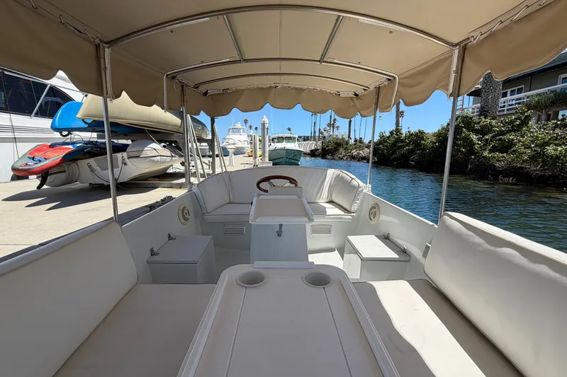 Slide: The Image of 1996 Duffy 16 boat interior with canopy, docked near waterway and other boats. - 11