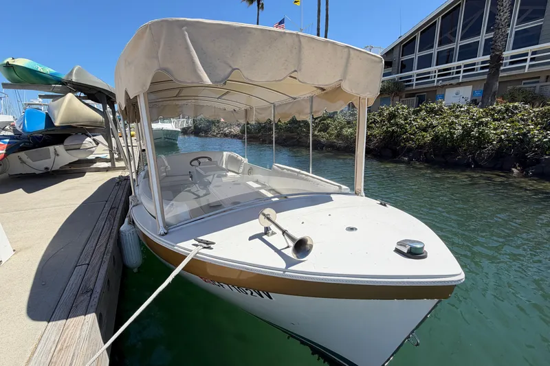 Slide: The Image of 1996 Duffy 16 boat docked in marina, featuring canopy and calm waters. - 2