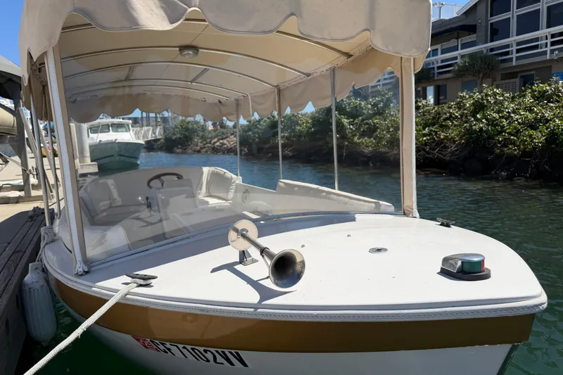 Slide: The Image of 1996 Duffy 16 boat docked, featuring canopy and horn, in a serene marina setting. - 3
