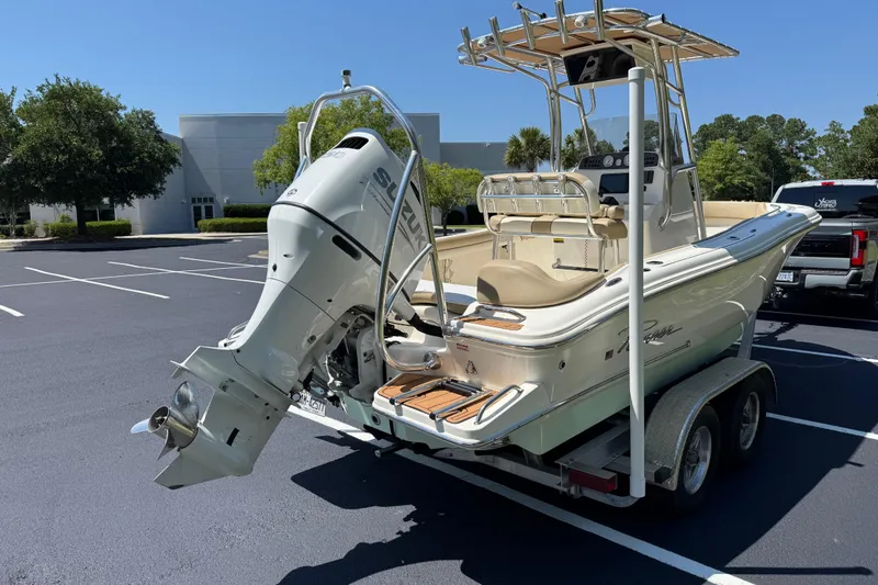 Slide: The Image of 2021 Pioneer 202 Islander boat on trailer with Suzuki outboard motor in parking lot. - 30