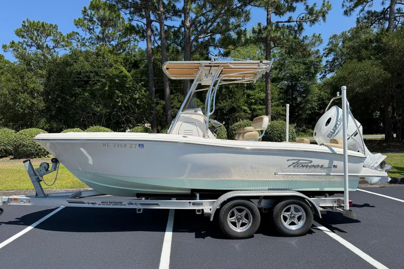 The Image of 2021 Pioneer 202 Islander boat on trailer, parked outdoors with trees in background. - 21