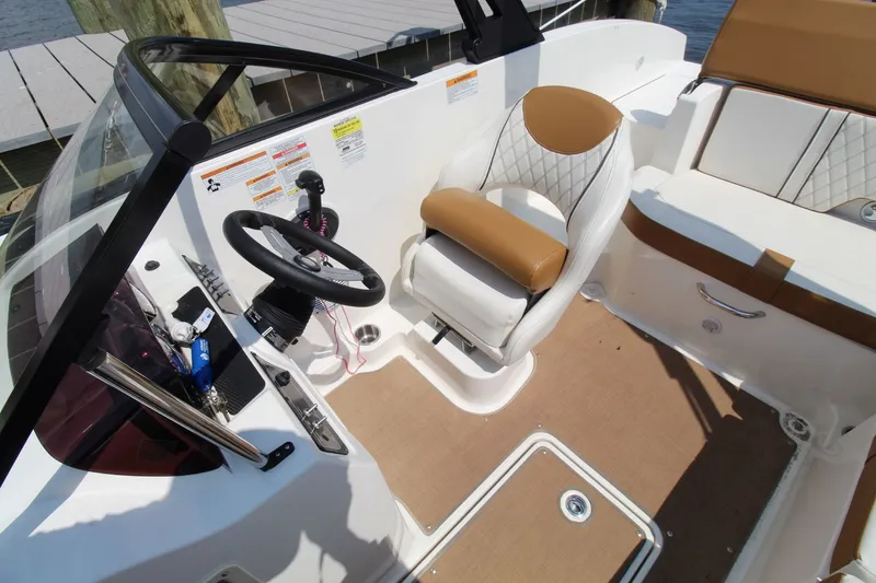 Slide: The Image of The image shows the cockpit of a 2022 Bayliner DX 2000 with a beige seat. - 12
