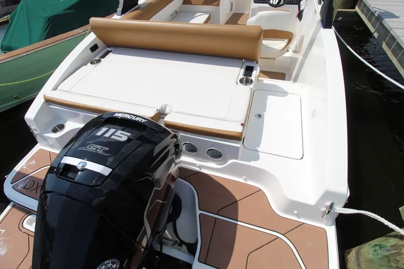 Slide: The Image of 2022 Bayliner DX 2000 with a Mercury 115 HP engine, brown upholstery, and white deck. - 16