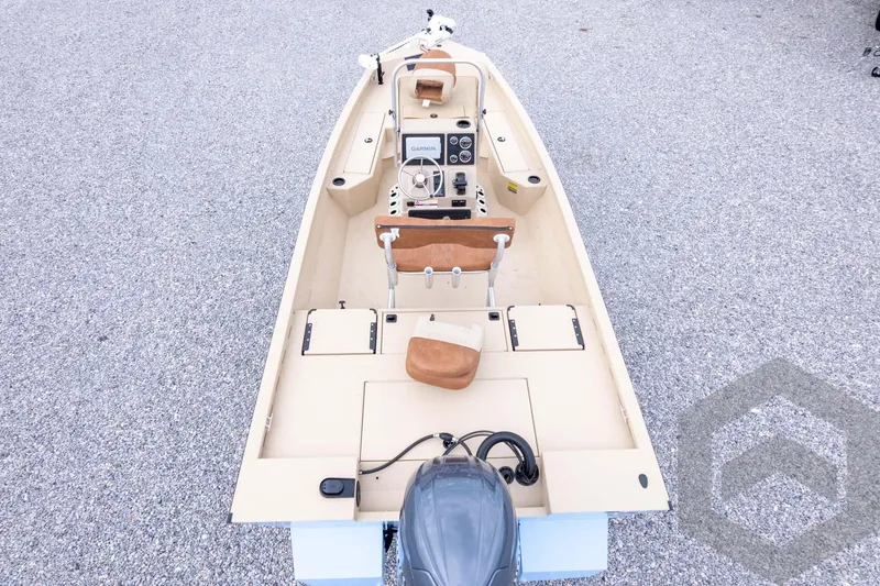Slide: The Image of 2026 G3 Bay 19 GX boat interior with steering console and seating on gravel surface. - 41