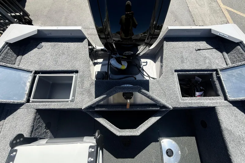 Slide: The Image of 2027 Tracker Pro Guide V-16 SC boat interior with storage compartments and motor. - 7