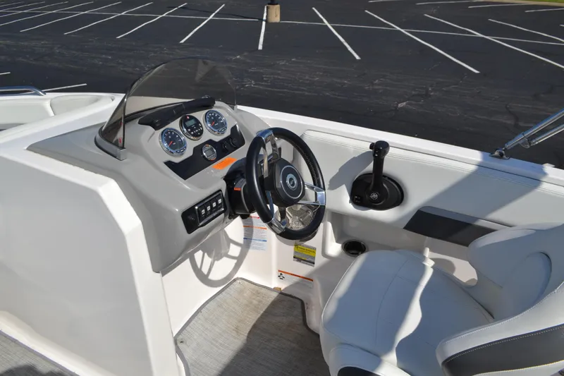 Slide: The Image of 2018 Chaparral 191 Suncoast boat cockpit with steering wheel and control panel. - 8