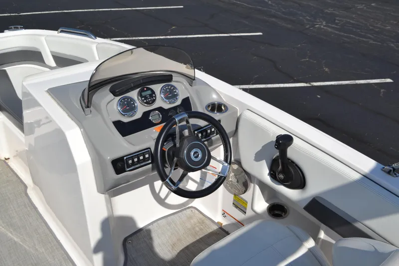 Slide: The Image of 2018 Chaparral 191 Suncoast boat dashboard with steering wheel and controls. - 7