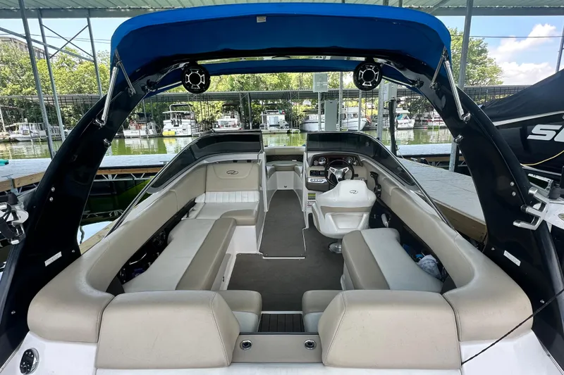 Slide: The Image of 2012 Regal 2300 RX Bowrider interior with seating and helm, docked at marina. - 5