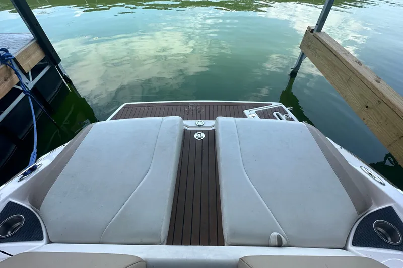 Slide: The Image of 2012 Regal 2300 RX Bowrider boat's rear deck by the water. - 7