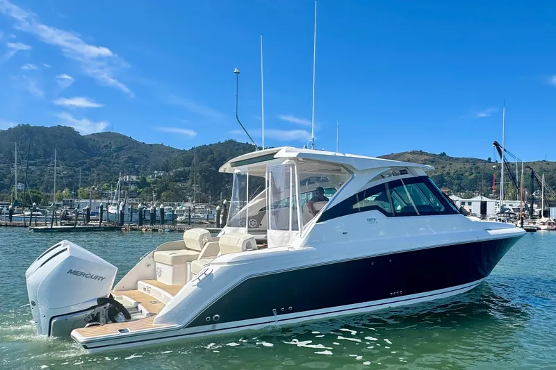 Slide: The Image of 2026 Tiara Yachts 34 LX cruising in a scenic marina with clear blue skies. - 1