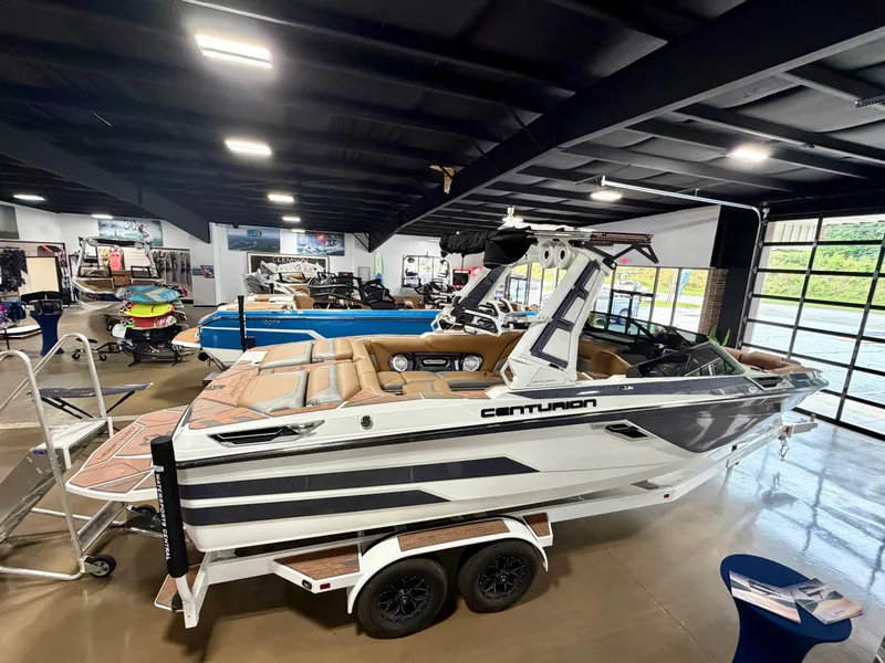 Slide: The Image of A 2022 Centurion Ri245 in a showroom. The boat features a sleek design and is on a trailer. - 6