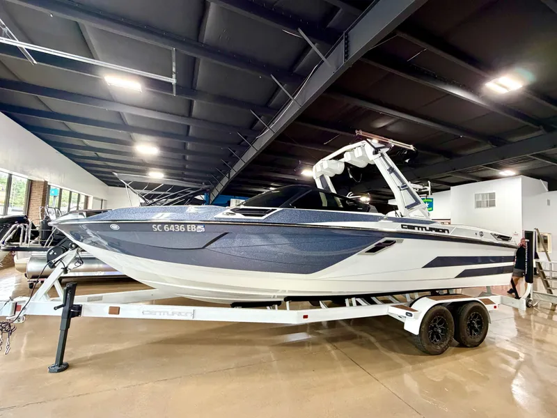 The Image of A 2022 Centurion Ri245 boat is on a trailer in a showroom. - 1