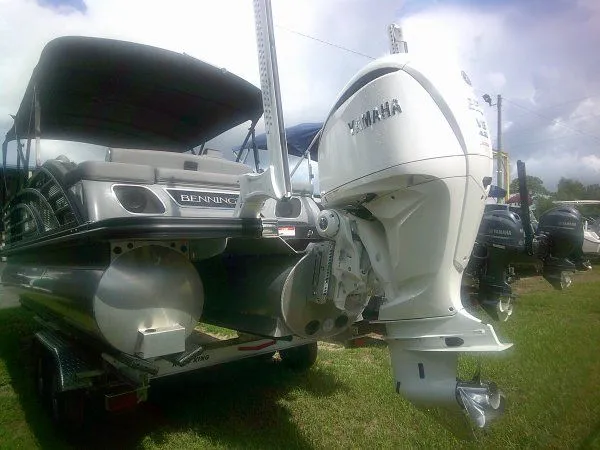 Slide: The Image of 2024 Bennington 23RSB Swingback Tritoon with Yamaha outboard motor, on a trailer. - 11