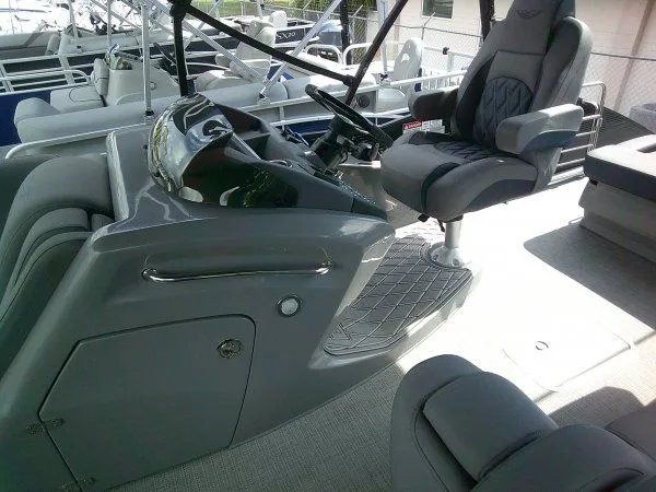 Slide: The Image of The image shows the cockpit of a 2024 Bennington 23RSB Swingback Tritoon with a sleek gray helm and cushioned captain's chair. - 6