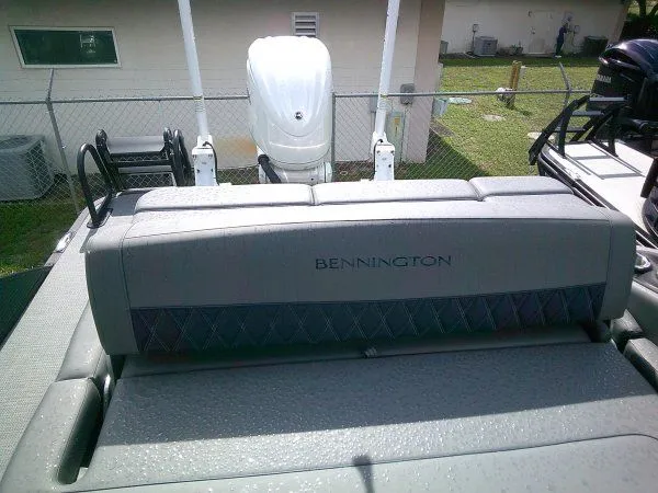 Slide: The Image of The image shows the rear of a 2024 Bennington 23RSB Swingback Tritoon with an outboard motor. - 3