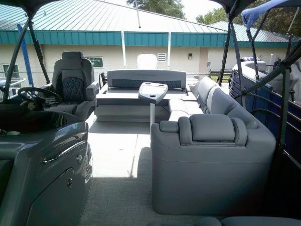 Slide: The Image of The image shows the spacious deck of a 2024 Bennington 23RSB Swingback Tritoon with gray seating. - 7