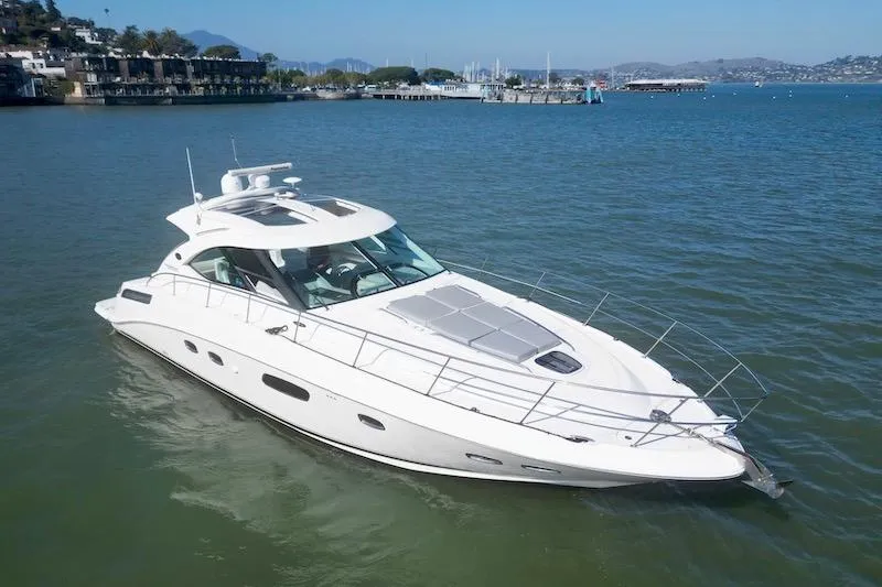 Slide: The Image of 2010 Sea Ray 470 Sundancer yacht cruising on a serene bay. - 4