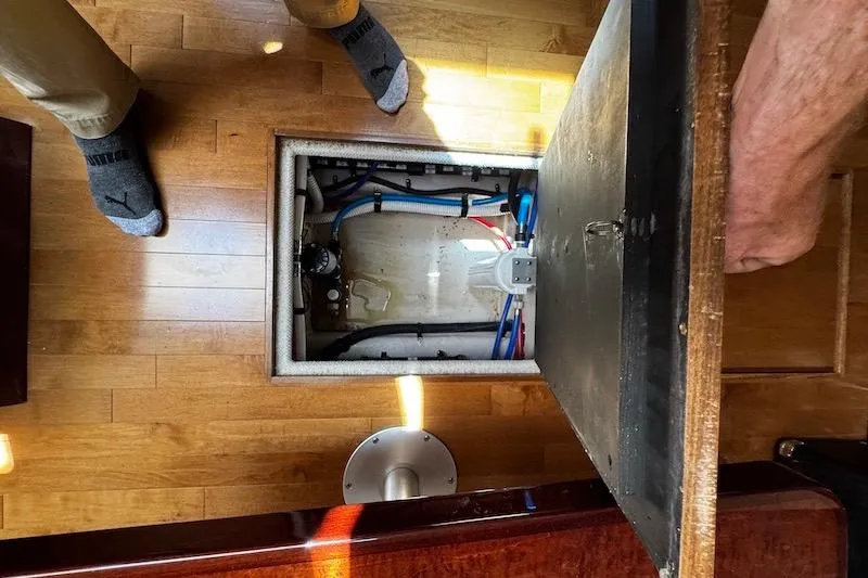Slide: The Image of Open hatch on 2010 Sea Ray 470 Sundancer, revealing interior components and wooden flooring. - 28