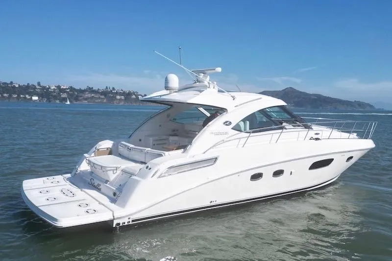 Slide: The Image of 2010 Sea Ray 470 Sundancer yacht cruising on calm waters under clear skies. - 2