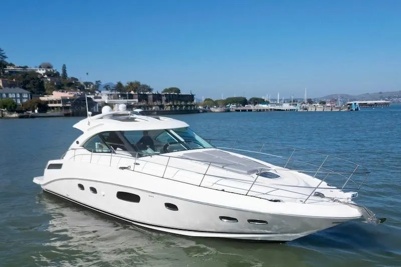 Slide: The Image of 2010 Sea Ray 470 Sundancer yacht cruising in a scenic harbor setting. - 13