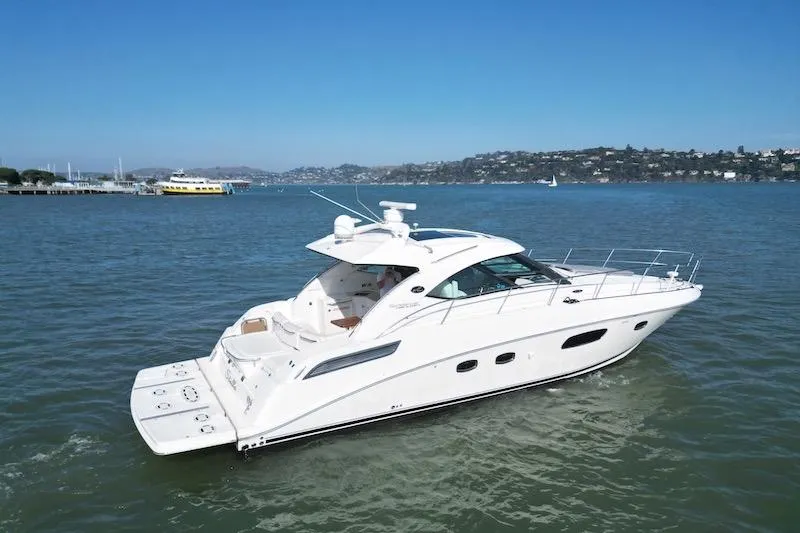 Slide: The Image of 2010 Sea Ray 470 Sundancer yacht cruising on a calm, scenic bay. - 11