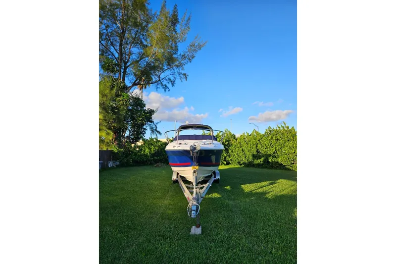 Slide: The Image of 2006 Monterey 298SC Super Sport boat on trailer, parked on grass under clear blue sky. - 4