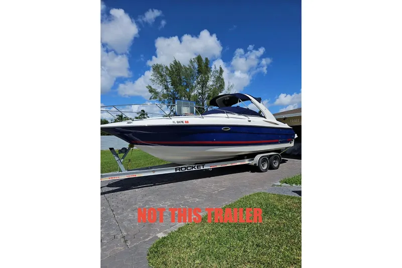Slide: The Image of 2006 Monterey 298SC Super Sport boat on trailer, blue sky background, "Not This Trailer" text. - 2