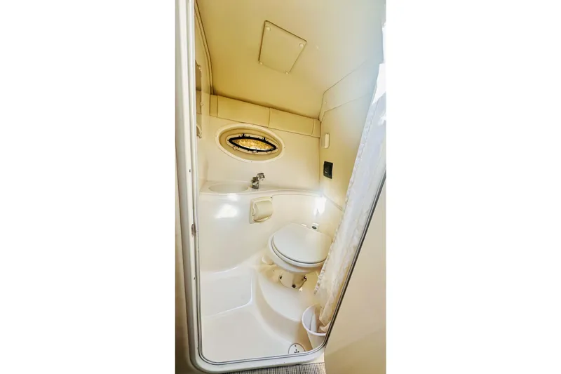 Slide: The Image of Compact bathroom in 2006 Monterey 298SC Super Sport boat with porthole and toilet. - 7