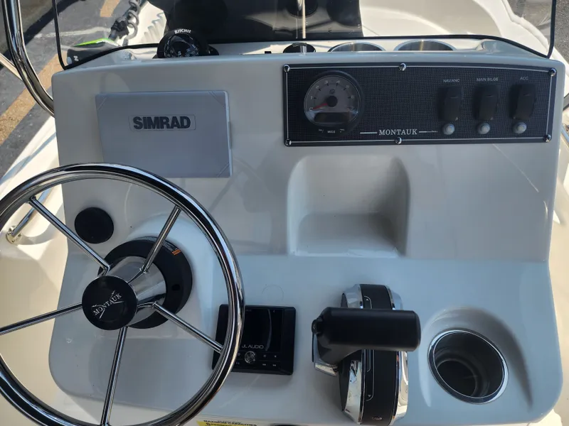 Slide: The Image of The image shows the helm of a Boston Whaler 150 Montauk with a steering wheel and instruments. - 12