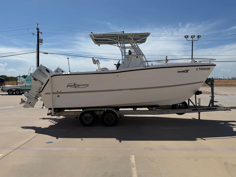 Slide: The Image of A 2002 PRO SPORT PRO KAT 2200 boat on a trailer, featuring an outboard motor and T-top. - 7