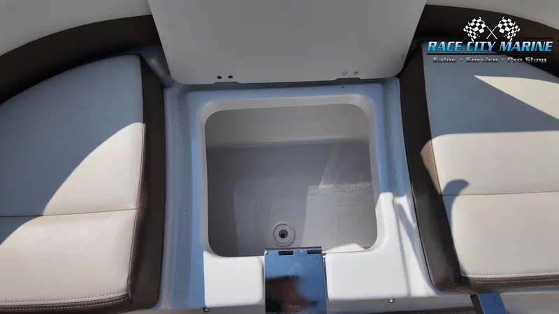Slide: The Image of An open storage compartment on a 2015 Chaparral 277 SSX boat, surrounded by cushioned seating. - 22